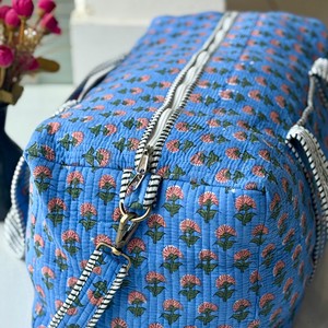Sac de voyage matelassé bleu à motifs floraux avec poignées rayées, fermeture éclair, design portable pour un usage décontracté en voyage - Product Image 3