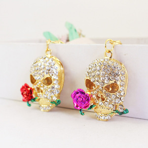 Portachiavi Teschio che Morde la Rosa con Strass, in Lega Dorata con Anello Apribile, per Decorazione Borsa a Tema Giorno dei Morti - Product Image 1