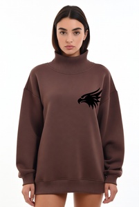 Hermosa mujer con una sudadera de cuello alto en un vibrante color rosa intenso, con delicado ribete de encaje y un audazco bordado de águila negra en el pecho. - Product Image 2