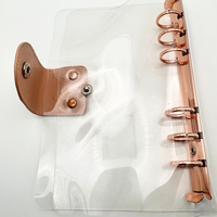 Protège-cahier en PVC transparent avec mécanisme à anneaux or rose et fermeture à bouton-pression |   Couverture rechargeable pour carnet/agenda (pliée)
