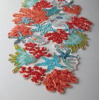 Chemin de table artisanal en perles sur le thème marin, avec coraux vifs et étoiles de mer turquoise, disponible à prix de gros.