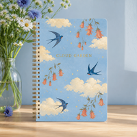 Carnet à spirale LABON Custom Cloud Garden, spirale dorée, ciel bleu, nuages crème, hirondelles bleues, campanules abricot, étoiles dorées