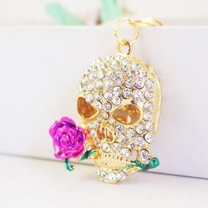 Portachiavi Teschio che Morde la Rosa con Strass, in Lega Dorata con Anello Apribile, per Decorazione Borsa a Tema Giorno dei Morti - Product Image 2