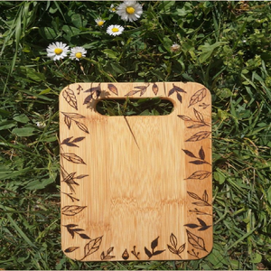 Planche à découper en bois gravée avec un bord en feuille, disponible à prix de gros pour cuisines inspirées de la nature et service rustique. - Product Image 1