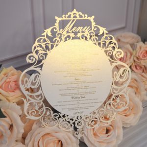 Tarjeta de Menú de Boda con Corte Láser Perlado Color Marfil, Marco con Cresta Ornamentada, Monograma Recortado e Impresión en Lámina Dorada - Product Image 1