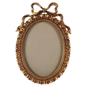 Miroir mural vintage luxueux, cadre ovale en métal doré, décor orné avec un motif de nœud papillon en relief, pour une présentation sur table et une décoration murale. - Product Image 1