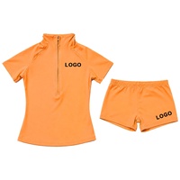 Ensemble de sport deux pièces pour femme avec logo personnalisé imprimé, comprenant un haut court à manches courtes et demi-zip et un short cycliste, idéal pour l'été et le yoga.