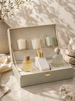 Boîte cadeau rigide de luxe sur mesure vert sauge avec couvercle à charnière, fermeture et insert moulé pour l'emballage d'un ensemble de parfum, bougie et diffuseur à bâtonnets.