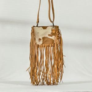 Bolso bandolera bohemio de cuero genuino con parche de piel de vaca y flecos largos para uso diario. - Product Image 1