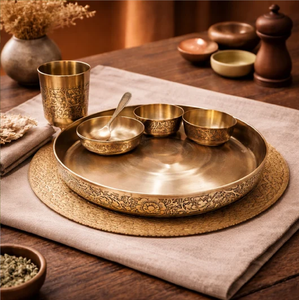 Intricately <b>carved</b> floral border Kansa bronze thali <b>set</b> with bowls, tumbler, <b>and</b> spoon, available at wholesale prices. - Product Image 1