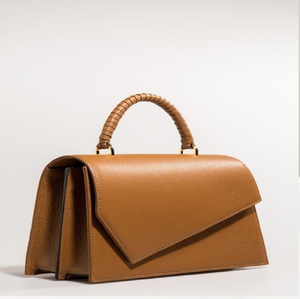 Bolso de mano arquitectónico de cuero color canela con solapa asimétrica única y asa tejida. Disponible a precios de mayorista. - Product Image 1