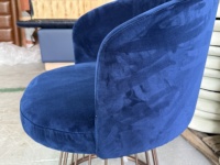 Fauteuil lounge en velours bleu foncé, dossier bas incurvé, base en fil métallique, design moderne pour hall d'hôtel, salon, bar, restaurant