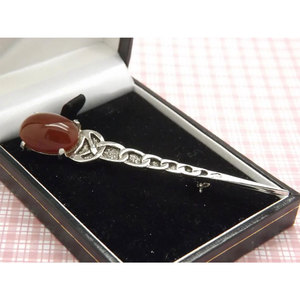 Broche Escocés con Diseño de Espada Estilizada, Pin para Kilt Hecho en Metal Plateado con una Piedra Ovalada de Color Marrón - Product Image 1