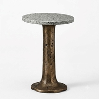 Table basse contemporaine avec plateau en marbre et base en métal patiné finition vintage pour la décoration de salon moderne