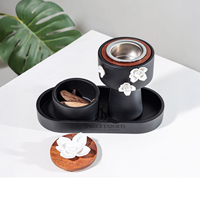 Boîte à encens moderne en métal noir mat et bois avec plateau et accents floraux blancs. Finition par peinture en poudre pour la décoration intérieure