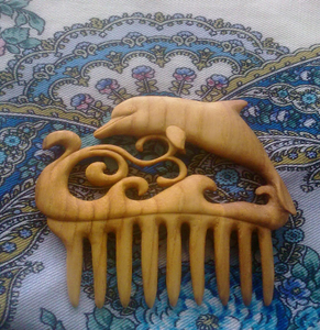 Peigne en bois artisanal avec un dauphin sautant sculpté au-dessus de vagues océaniques tourbillonnantes, disponible à prix de gros. - Product Image 1