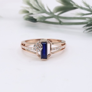 Anillo de compromiso de oro rosa premium con zafiro azul talla baguette, diseño floral con micro pavé y detalles de diamantes, anillo solitario de doble aro. - Product Image 1