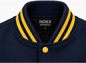 Chaqueta Varsity Bordada en Azul Marino y Dorado para Hombre de Index Apparel, con Bloques de Color en las Mangas y Botones a Presión, Estilo Béisbol - Product Image 6