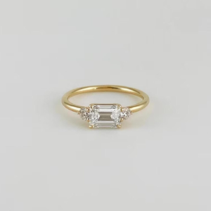 Anillo de compromiso minimalista de oro con moissanita de corte esmeralda y tres piedras, anillo de promesa delicado con piedras laterales redondas - Product Image 1