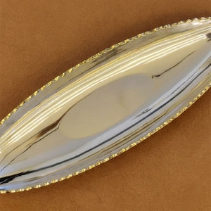 Ce plateau élégant finition argentée présente un design ovale pointu et une bordure dorée détaillée, offrant un luxe pour le service et la décoration. - Product Image 2