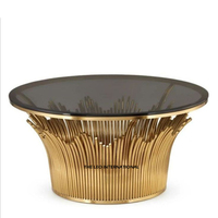 Table basse ronde en aluminium avec base en forme de feuille et plateau en verre transparent, finition dorée