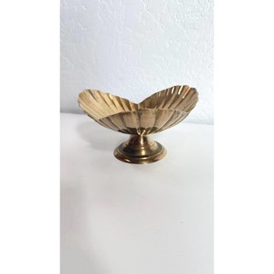 La superficie dorada pulida de un tazón de latón refleja la luz como un pequeño sol dorado sobre la mesa. - Product Image 1