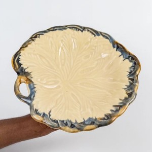 Plato de cerámica hecho a mano con diseño de hojas en relieve, borde esmaltado en azul rústico y asa decorativa lateral para exhibición en mesa. - Product Image 1