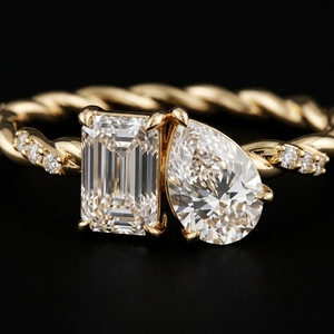 Bague de fiançailles en or jaune 18 carats avec deux pierres, taille émeraude et taille poire, motif Toi et Moi, avec accent de diamants sur l'alliance torsadée - Product Image 1
