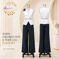 Costume élégant pour femmes, sans manches et cintré à la taille, en noir et blanc, adapté aux occasions formelles.