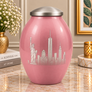Urne commémorative en métal rose poudré avec une détaillée sculpture en argent représentant la Statue de la Liberté et un couvercle bombé lisse - Product Image 1