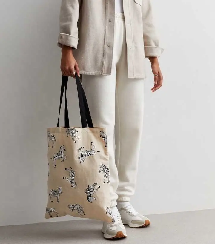 クリームゼブラプリントキャンバストートバッグ綿で作られ、かわいいゼブラパターンで飾られています