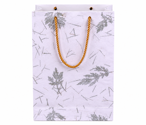 Esta es una auténtica bolsa de regalo de papel botánico hecha a mano con un hermoso diseño de hojas naturales y elegantes asas de cuerda dorada. - Product Image 1