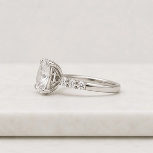 Bague de fiançailles en platine avec diamant ovale taille brillant, sertie de griffes et de diamants latéraux, style classique pour femme - Product Image 2