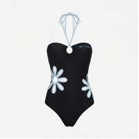 Maillot de bain une pièce noir pour femme NORMA APPAREL avec appliques marguerites bleu clair, encolure halter, tissu extensible