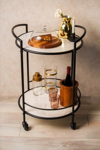 Carrito de bar circular de metal blanco con base de mármol en la parte superior e inferior, varillas de metal negro y 4 ruedas en la parte inferior. - Product Image 2