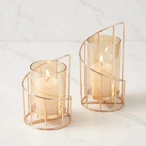 Ensemble de bougeoirs géométriques dorés élégants avec des cadres incurvés et des coupelles en verre ambré pour des accents de table modernes - Product Image 1