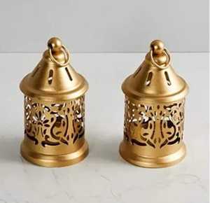 Paire de lanternes en métal noir avec base carrée, panneaux en verre, dessus pyramidal, poignée circulaire, bougies blanches en forme de pilier, design haut et petit. - Product Image 4