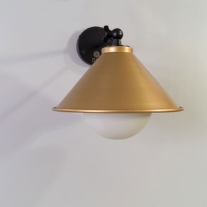 Modern cone <b>wall</b> <b>sconce</b> with a sleek black mounting arm and warm gold metal shade Designed to provide soft ambient <b>lighting</b> - Product Image 1