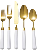 Ensemble de couverts en or avec manches facettés blancs et couverts élégants et modernes avec couteaux, fourchettes et cuillères pour la restauration et l'hôtellerie