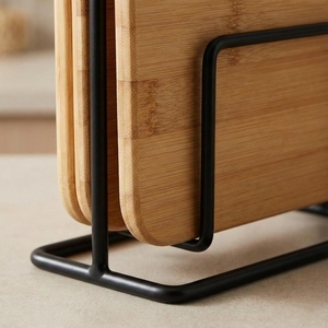 Ensemble de planches à découper en bois, 3 tailles différentes, soigneusement disposées sur un support de rangement élégant en métal noir mat, pour couper les légumes. - Product Image 5