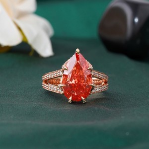 แหวนเพชรเม็ดเดี่ยวทรงลูกแพร์สีแดงสด 6.01 กะรัต ทำจากทองคำขาว 18K ผสมทองคำชมพู 14K และแพลตตินั่ม ประดับด้วยมรกตและเพชรทรงเรเดียนท์คัท - Product Image 1