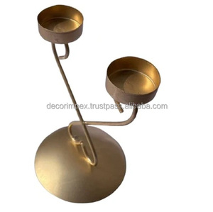 Un double bougeoir doré décoratif, probablement en métal. Il présente un design moderne - Product Image 1