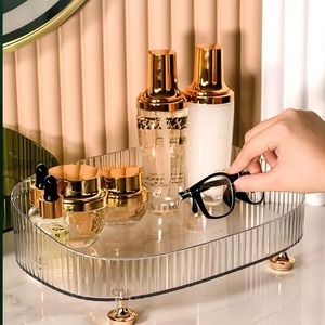 Support de présentation cosmétique de luxe avec bords surélevés et pieds décoratifs en métal doré – Coiffeuse de salle de bain transparente et élégante - Product Image 1