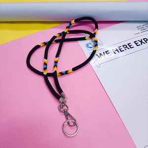 Chaîne de corps perlée faite à la main et colorée, portée par une femme en chemise blanche et avec une carte d'identité, mettant en valeur l'artisanat vibrant des artisans. - Product Image 5