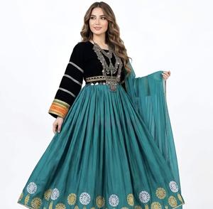 Mujer con un vestido largo plisado en color azul verdoso, con un corpiño de terciopelo negro con adornos tribales de monedas plateadas y un motivo de sol dorado bordado. - Product Image 3