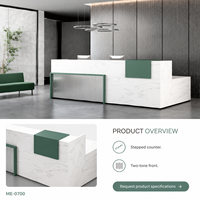 Bureau de réception moderne en L en bois avec surface aspect marbre blanc, accent vert et façade grise côtelée pour projets de hall d'entrée
