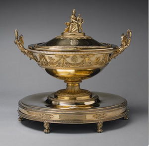 Sopera neoclásica sobre un pedestal elevado con un adorno decorativo con figuras familiares. Estilo antiguo disponible a precios de mayorista. - Product Image 5