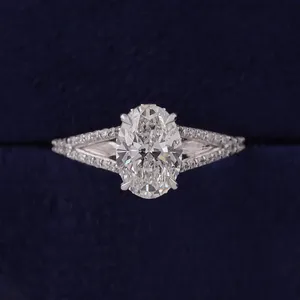 Anillo de compromiso de diamante de corte ovalado en platino y oro blanco con engaste de cuatro puntas, banda de tallo dividido con pavé y doble fila de piedras de acento. - Product Image 1