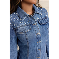 Veste en jean ajustée ornée de perles, également appelée veste en jean à perles ou veste trucker ornée.