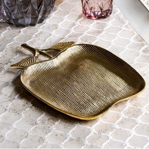 Magnifique plateau de service en métal doré en forme de pomme, avec surface linéaire texturée et pied élégant orné de détails de feuilles. - Product Image 1
